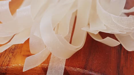 raw rice noodles on a wooden cutting board