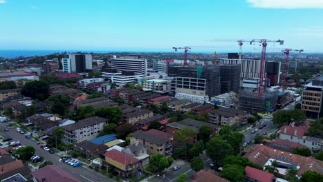 Drone-aerial-building-towers-apartments-with-cranes-on-construction-site-Randwick-hospital-engineering-lifting-Sydney-city-Australia