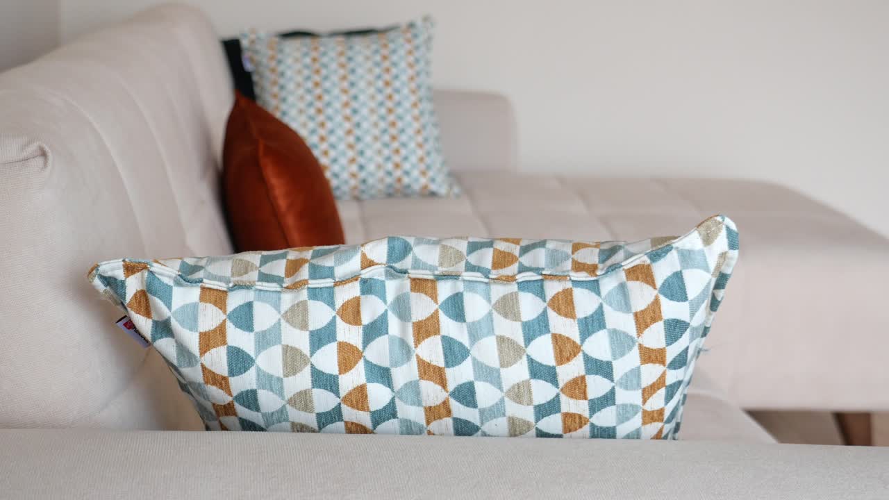 sofá beige con almohadas con patrones