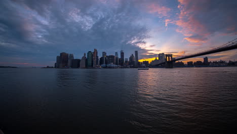 East-River-boat-traffic-twilight-timelapse,-Brooklyn-Bridge-and-city-skyline