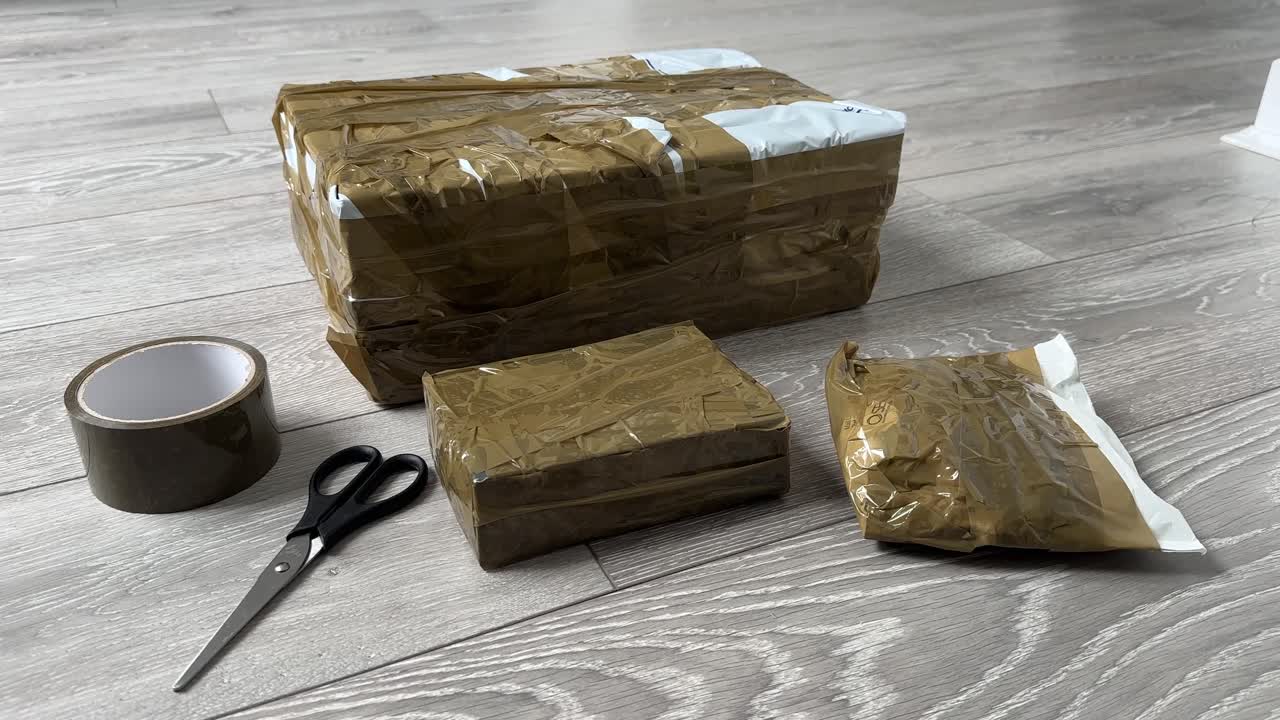 Ebay parcels wrapped Close Up of Cardboard Packages Wrapped with Duct Tape for Shipping and Delivery scissors