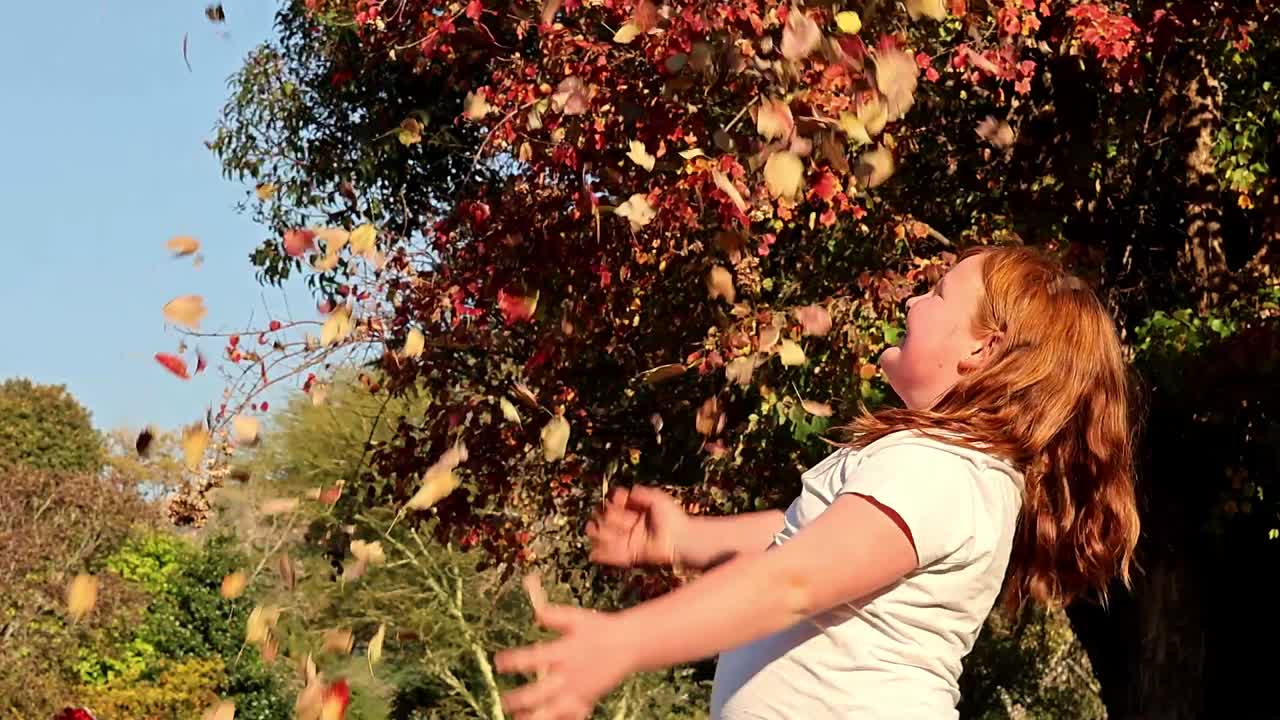 Girl Playing in Autumn Leaves
