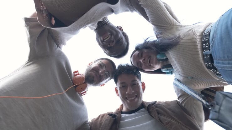 Gruppo di studenti di diverse etnie che si abbracciano in cerchio