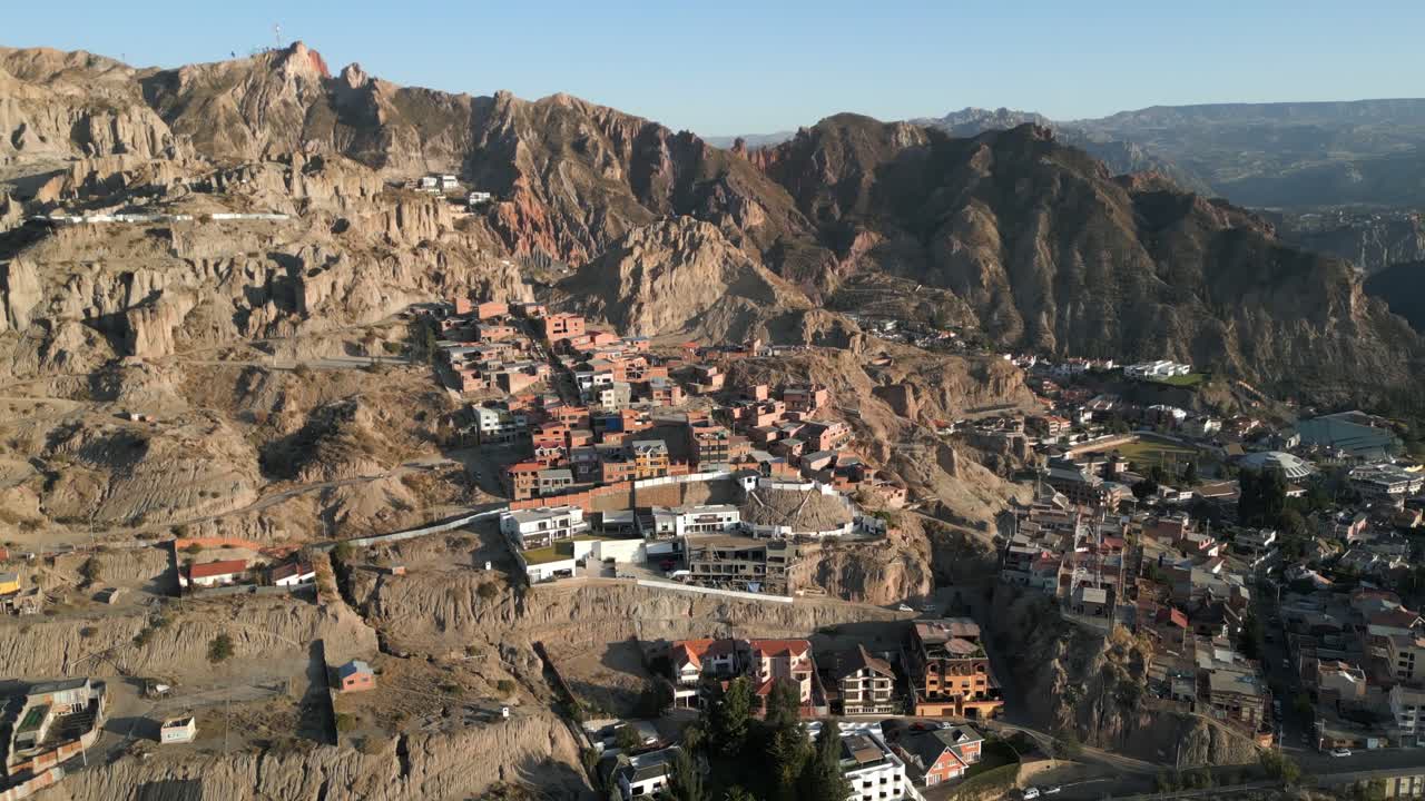 drone aéreo hacia adelante disparado sobre la ciudad de la paz, distrito de zona sur en bolivia al amanecer