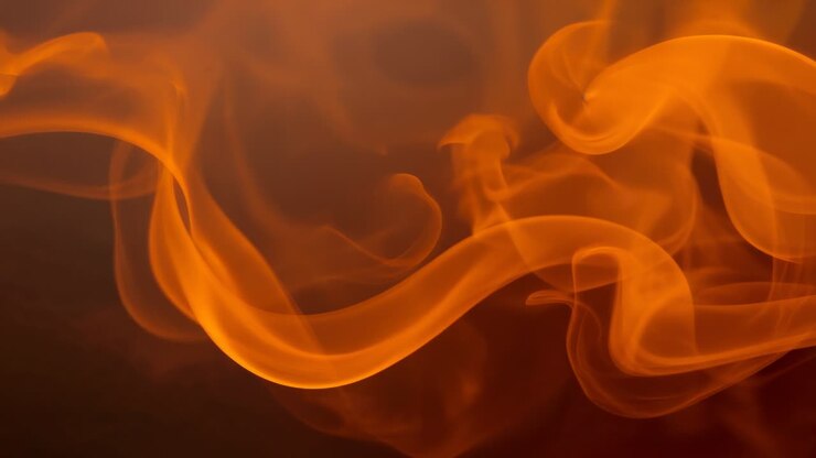 Activating smoke generator producing vibrant orange plume swirling in studio, showing fluid loops