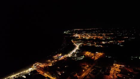 stunning 4k drone footage of the sea at night, with illuminated coastline and city lights