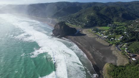 foamy waves splashing sandy shore in piha beach, north island, new zealand - aerial drone shot