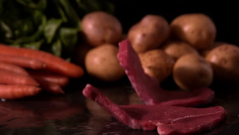 beef steak falling in front of vegetable selection