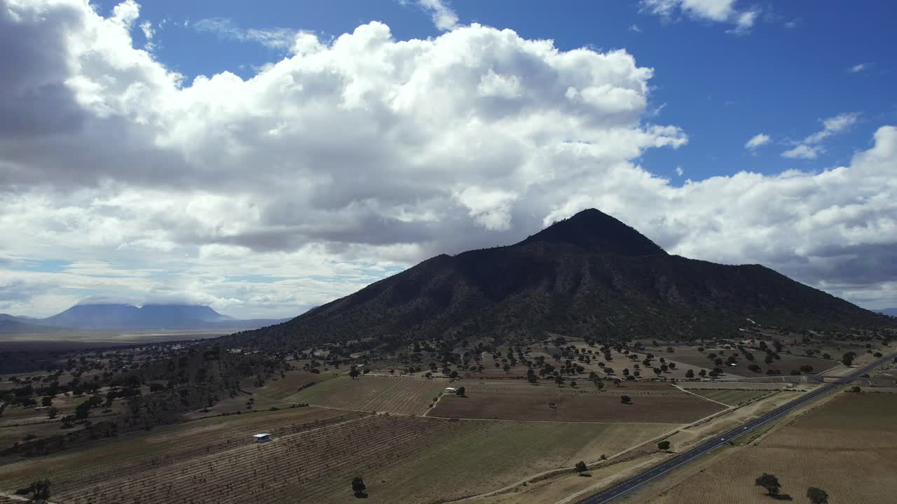 volando lentamente lejos de una montaña y una carretera en méxico