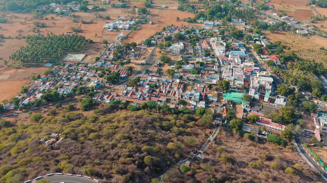 Stunning aerial view of Sivanmalai temple perched on top of a mountain with a vibrant village at its foothills, blending divine architecture, spiritual heritage, and scenic landscapes