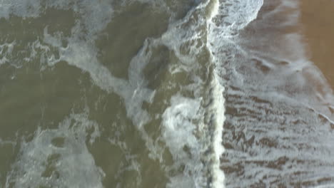 Schnelle-Luftaufnahme-über-Dem-Mächtigen-Meer,-Das-Wellen-An-Einem-Goldenen-Strand-Bricht