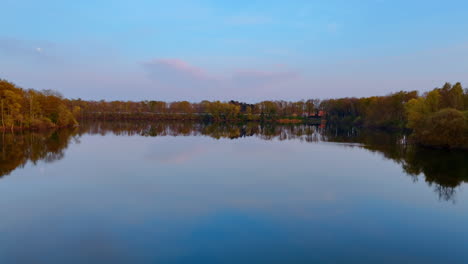 lush lake in netherlands. calm waters reflect trees and sky in a serene landscape during twilight in the netherlands, showcasing nature's beauty