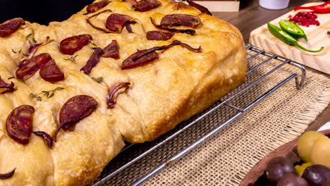 Focaccia-Italiana-Tradicional-Con-Pepperoni,-Tomates-Cherry,-Aceitunas-Negras,-Romero-Y-Cebolla---Focaccia-Casera-De-Pan-Plano