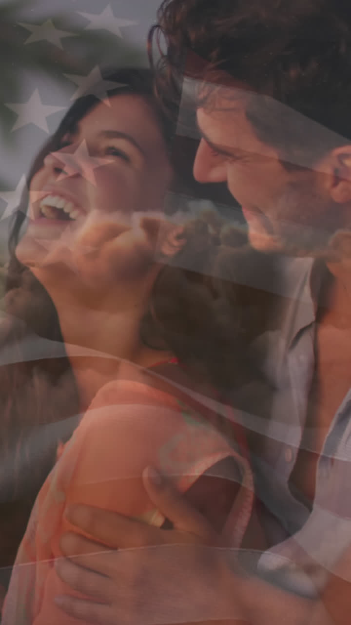 Animación de la bandera de los Estados Unidos de América sobre una feliz pareja caucásica en la playa.