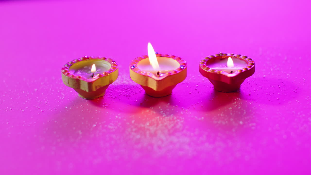 primer plano de las velas coloridas que queman celebrando diwali sobre un fondo púrpura