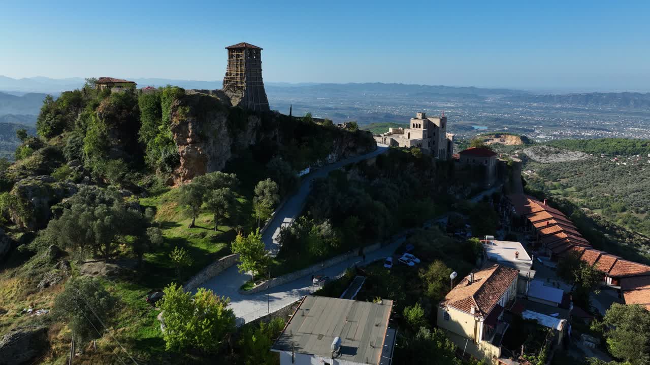 Kruje Castle on top of green hill in sunny Albania, wide aerial parallax