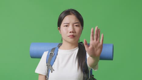 woman with backpack making stop gesture