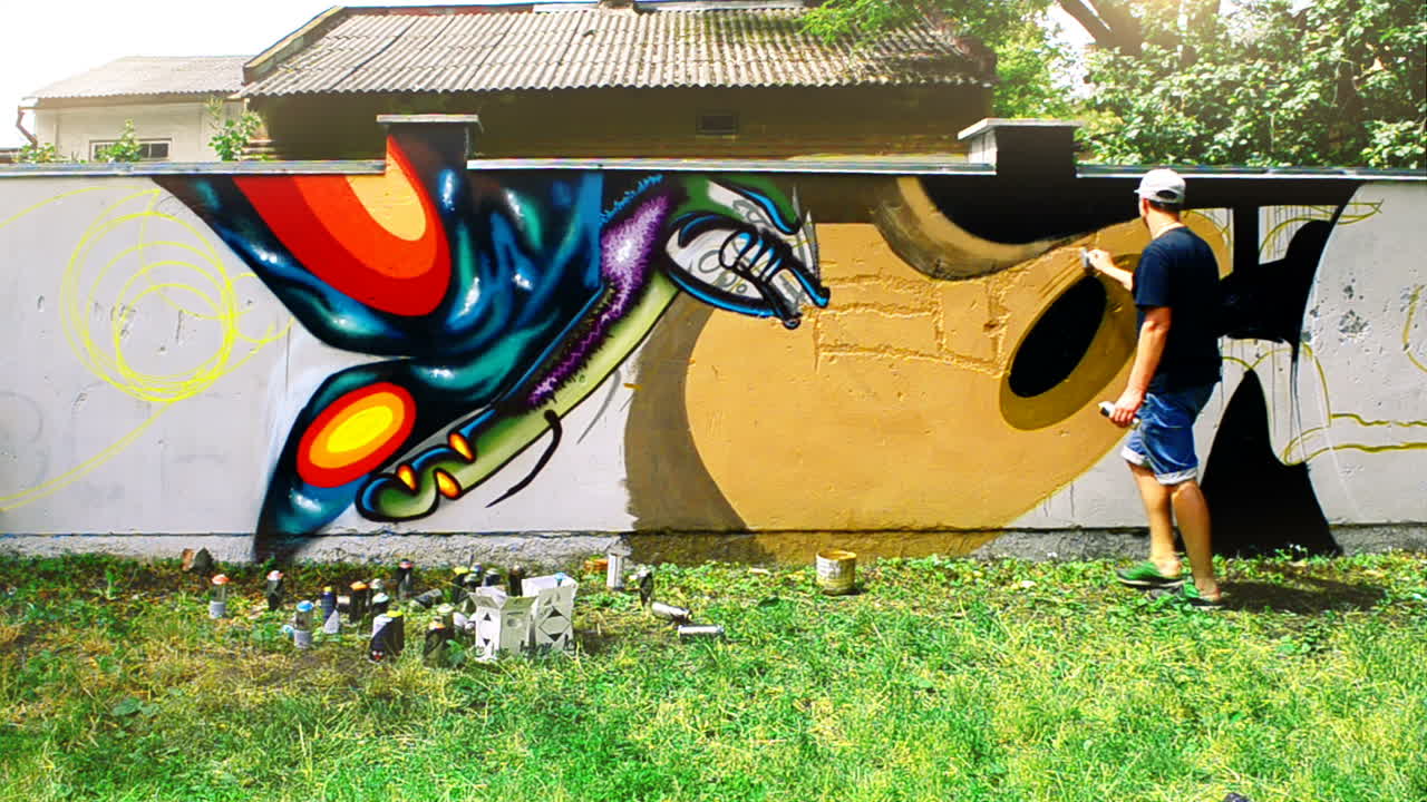 L'artista disegna graffiti su una recinzione. Disegno astratto