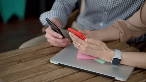 personas que colaboran en computadoras portátiles con teléfonos
