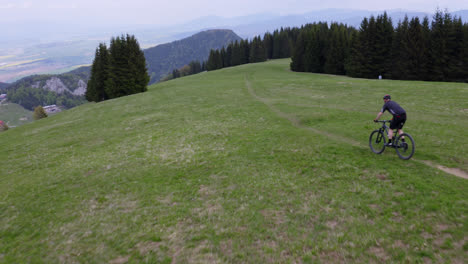 Mountain-bike-rider-cycling-through-the-beautiful-and-lush-rural-countryside-of-Liptov,-Slovakia