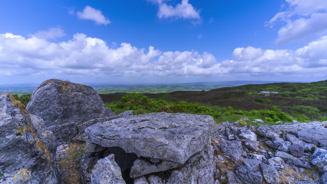 Tidsforløb af landligt landskab med neolitisk klippeformation i forgrunden på en solrig og skyet dag set fra Carrowkeel i County Sligo i Irland
