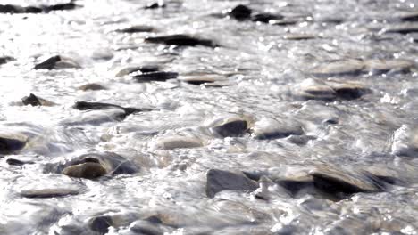 Water-flowing-over-rocks-and-pebbles-in-4K