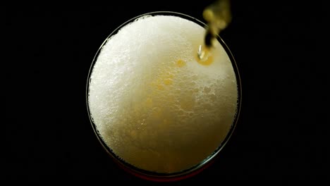 beer poured in glass against black background 4k