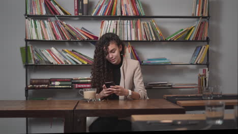 young woman in a cafe using smartphone