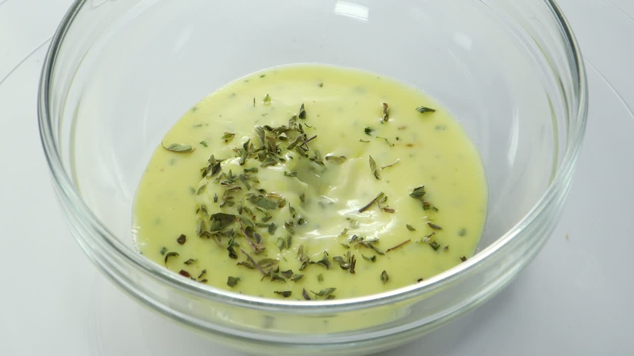 mezclar aioli casero con una cuchara en un recipiente de vidrio
