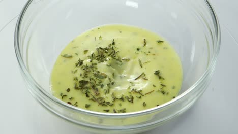 mezclar aioli casero con una cuchara en un recipiente de vidrio