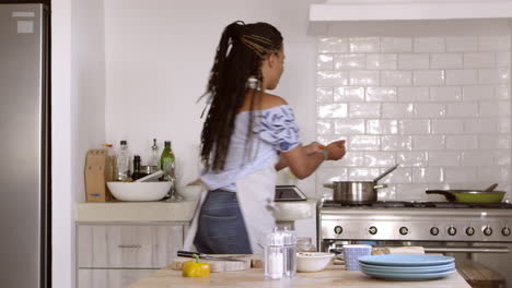 front view of woman chopping and cooking ingredients at home, shot on r3d