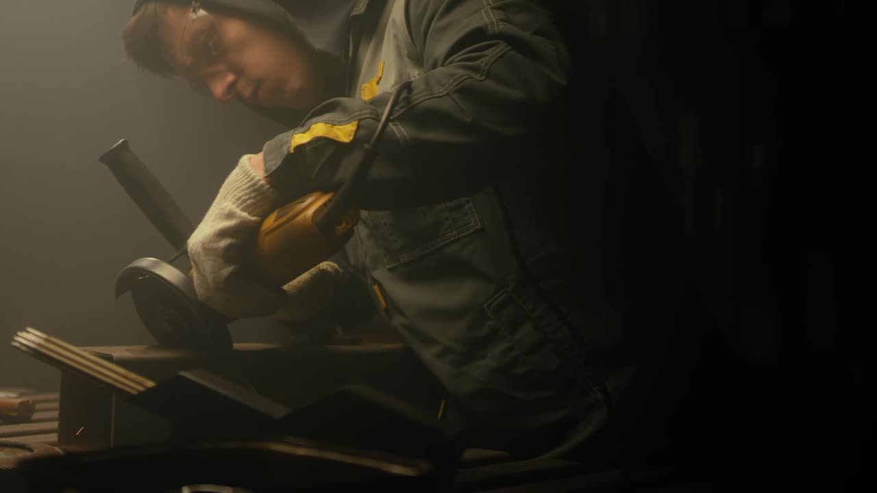 Industrial worker cutting metal with many sharp sparks. Male using special tool for cutting metal at workshop. Sparks flying from metal processing. Slow motion. 4K video. Shot on RED