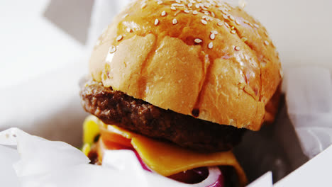 hamburger in a take away container on table