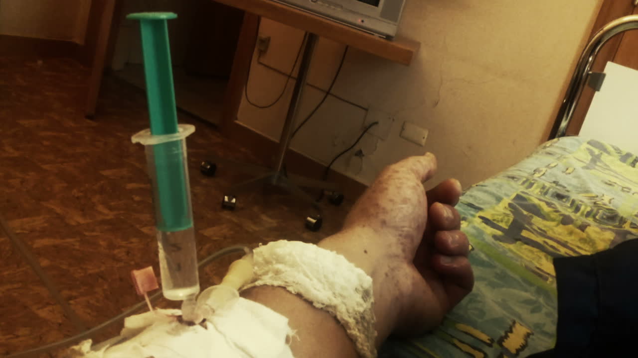 mano de una persona enferma con jeringa y goteo