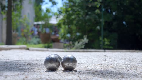 ground circular shot of three metallic balls placed on sand in house garden