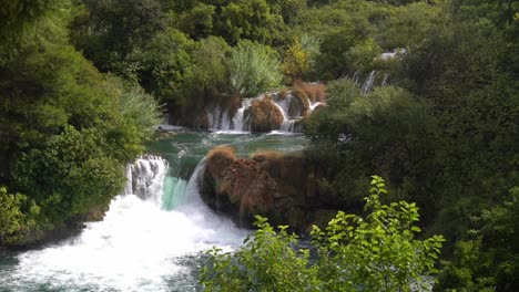 large waterfall pouring from one pond to another blue pond in krka national park in croatia at ¼ speed