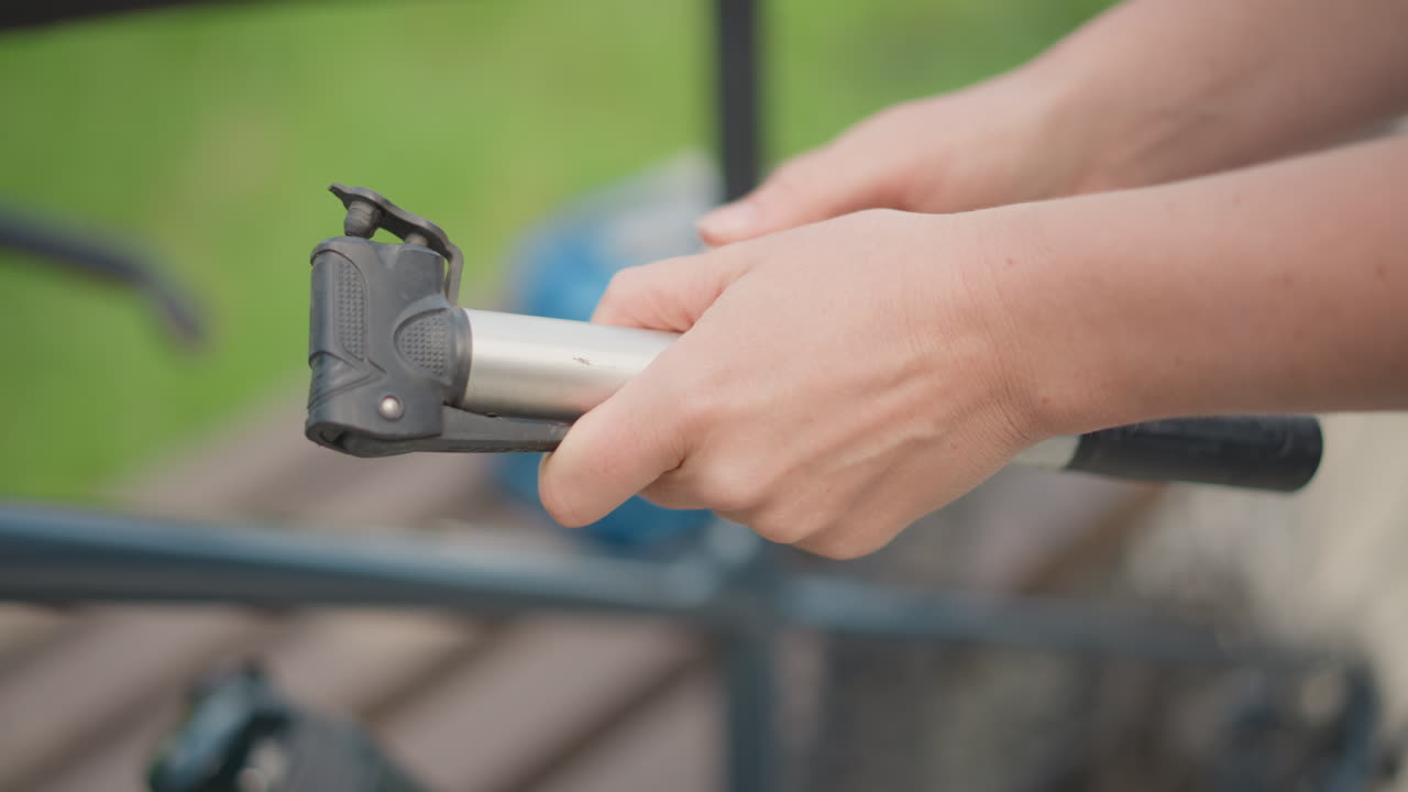 Primo piano di mani femminili che chiudono un lucchetto da bici su una panchina, chiave di metallo inserita, presa delicata, sfondo sfocato con telaio di bicicletta, ambientazione in un parco urbano, luce mattutina, routine cauta, sensazione di indipendenza