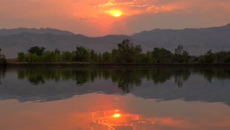 reflejo de la puesta de sol sobre la superficie del lago durante los incendios forestales de finales de agosto de 2020 en colorado