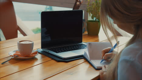 mujer trabajando en una computadora portátil en un café