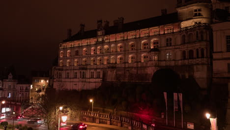 a beautifully lit royal castle of blois at night with warm tones, historic ambiance