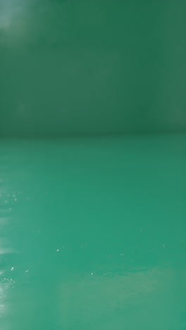 Rubber balls and rings falling in heap on green. Satisfying 3d animation. Vertical orientation