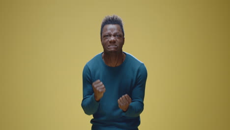 man expressing anger and frustration on yellow background
