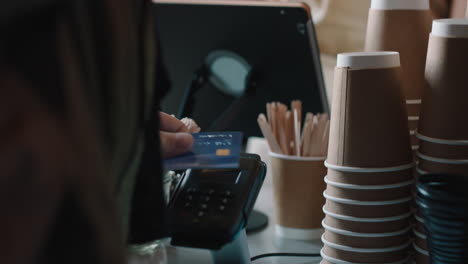 happy barista woman serving customer using credit card making contactless payment buying coffee spending money in cafe