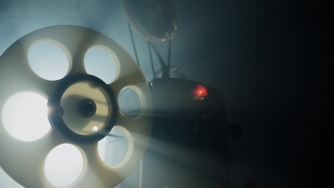 con un carrete de película giratorio y rayos de luz. viejo proyector de películas