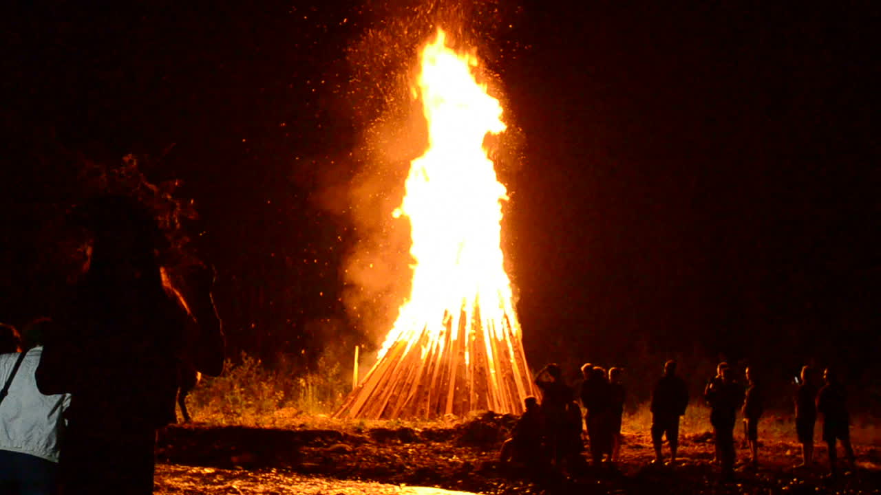 Gente alrededor de una hoguera. Hoguera para la festividad de Iván Kupala, julio, verano, Ucrania