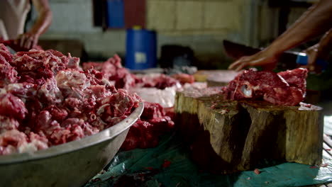 hombres filipinos matando y cortando carne de cerdo en un tazón grande