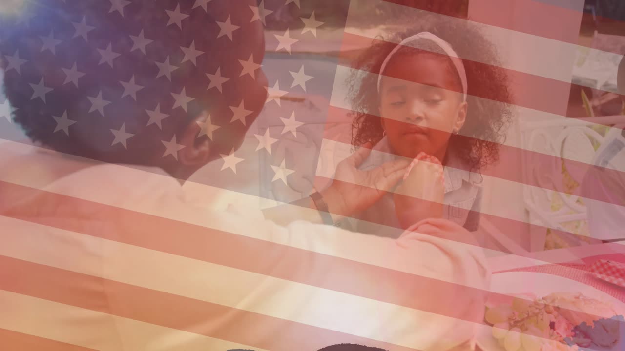 animación de la bandera de los estados unidos de américa sobre una madre afroamericana limpiando la cara de sus hijas