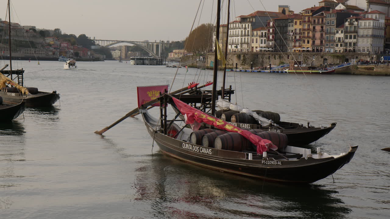 Traditional Rabelo Boats Carrying Wine Barrels At Douro River In Porto, Portugal. Wide shot