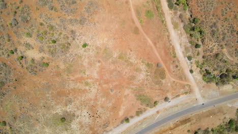 top down aerial of dirt roads connected to a motorway in rural africa