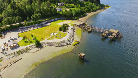 waterfront playground park area and abandoned old broken dock pier in port alberni region, british columbia canada, aerial view